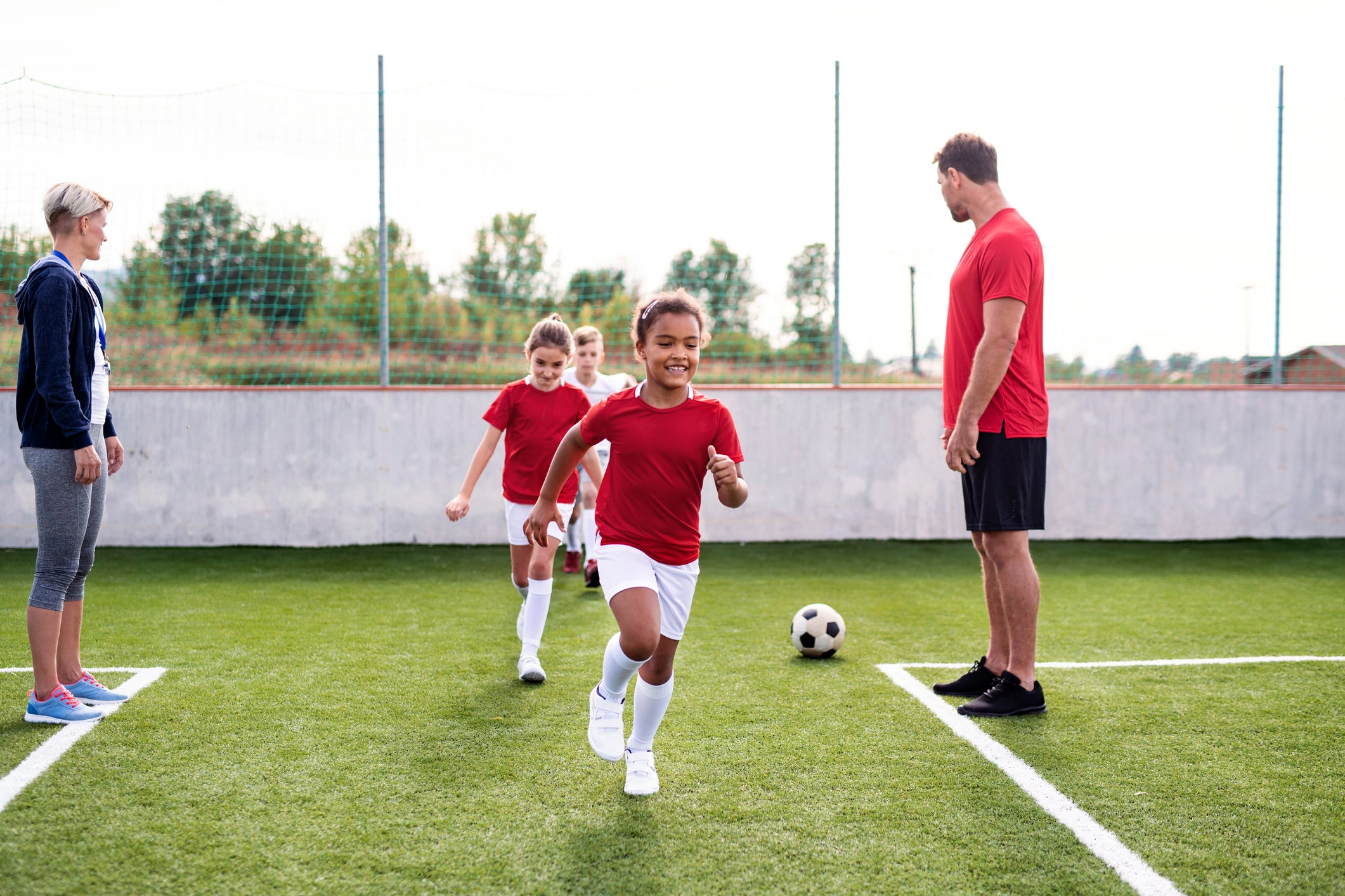 Niños en una cancha de fútbol entrenando Fútbol Sala