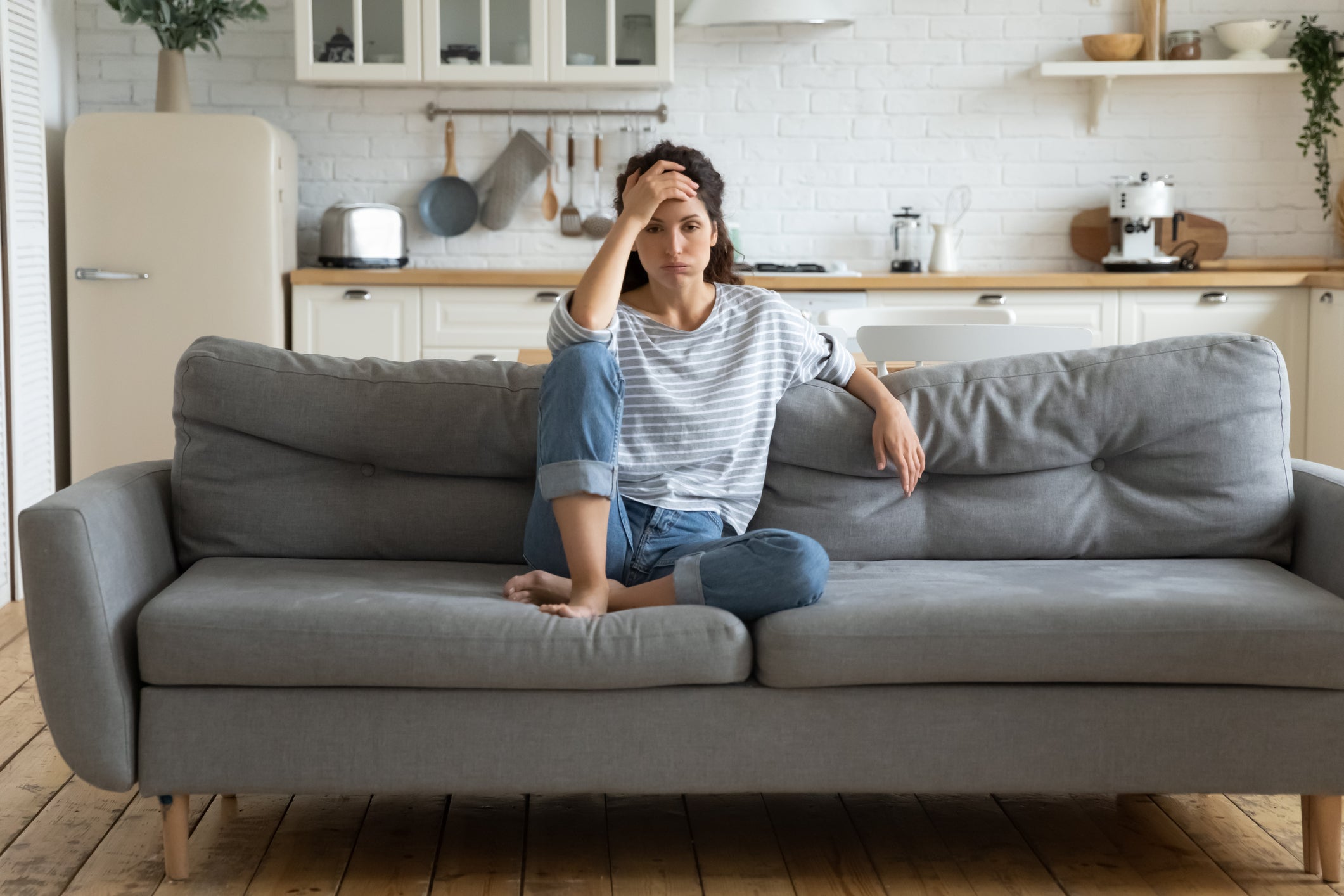 Mujer sentada en un sofá con falta de energía