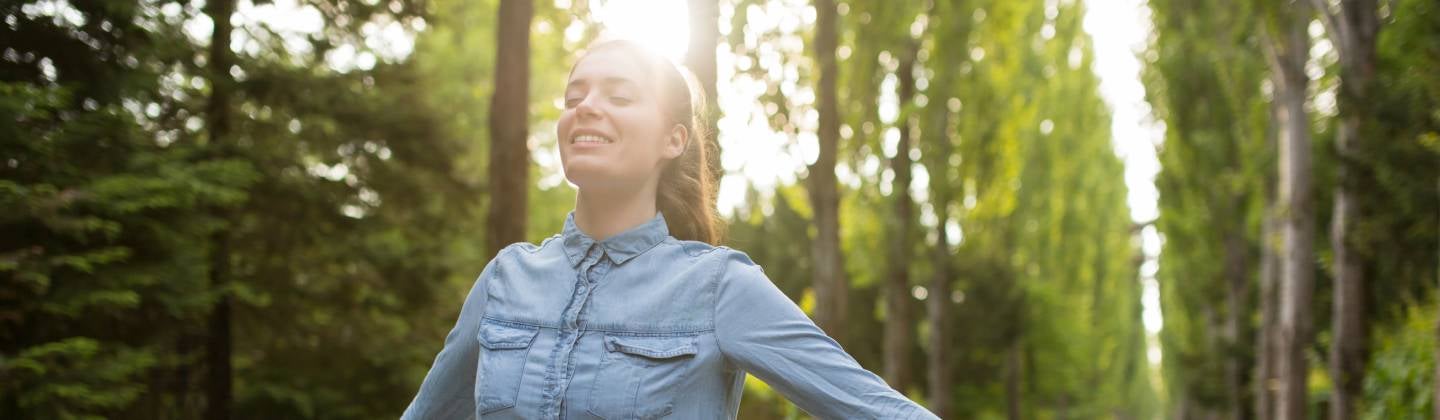 Mujer disfrutando del aire libre con los ojos cerrados