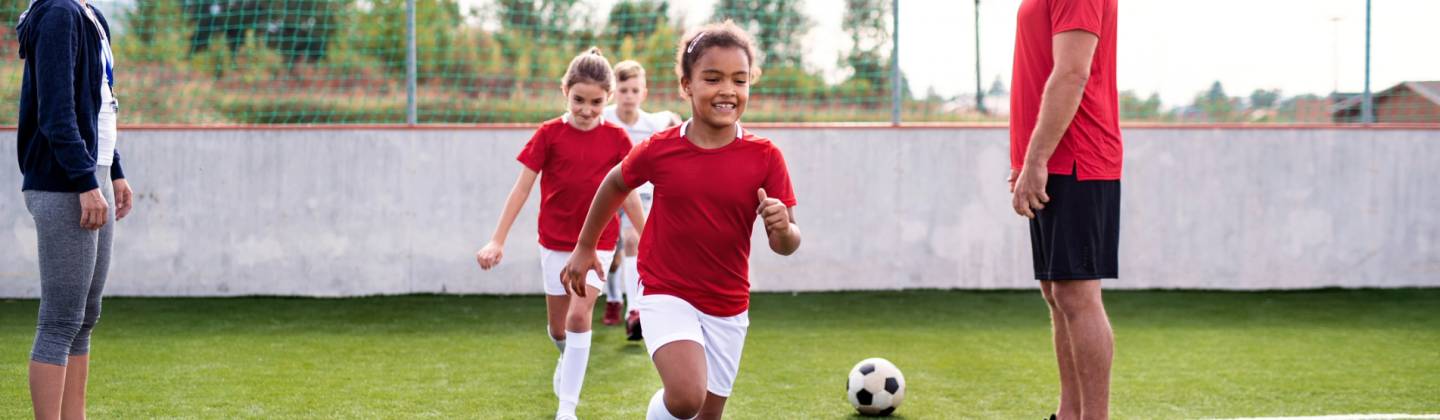 Niños en una cancha de fútbol entrenando Fútbol Sala