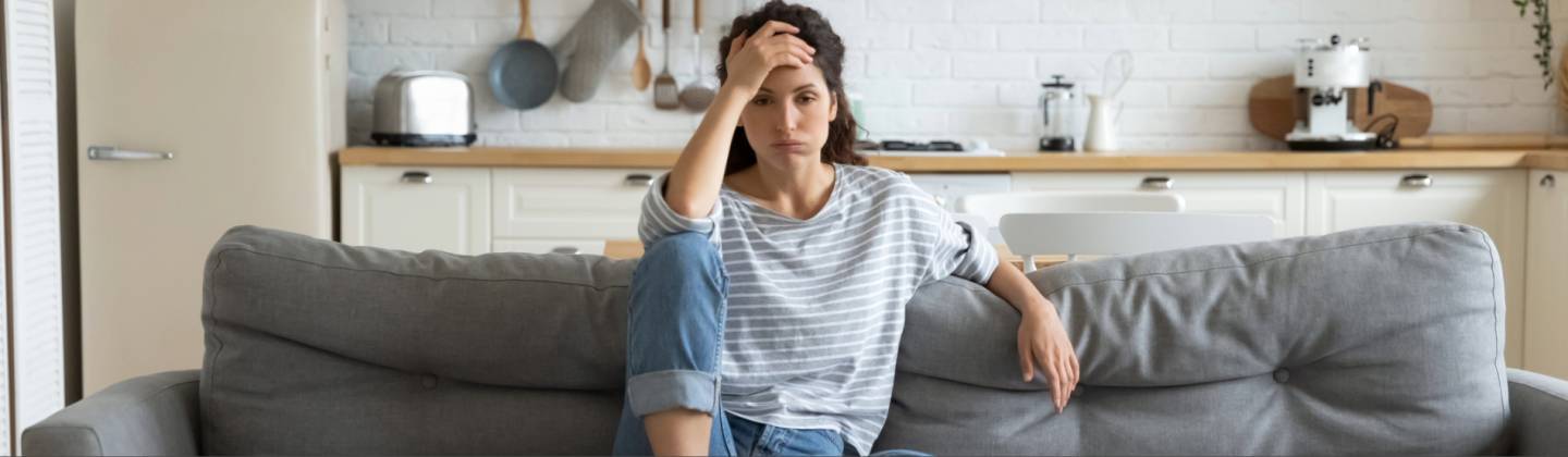 Mujer sentada en un sofá con falta de energía