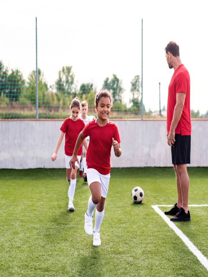 Niños en una cancha de fútbol entrenando Fútbol Sala